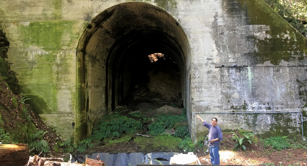 Jose Bernebe stands in front of the Glenwood Tunnel historic train to san jose from santa cruz