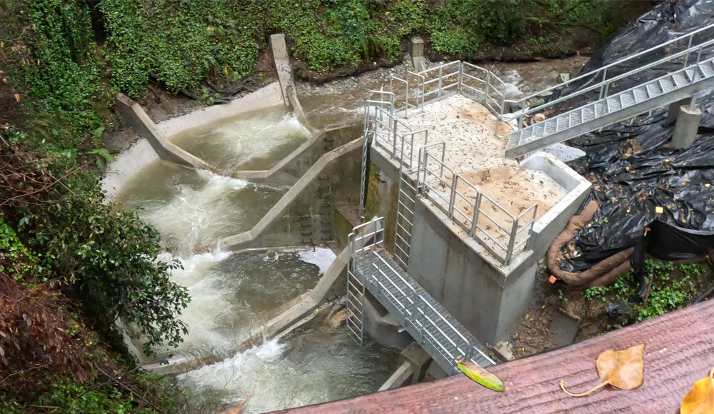 View from above of a river flowing down a concrete structure