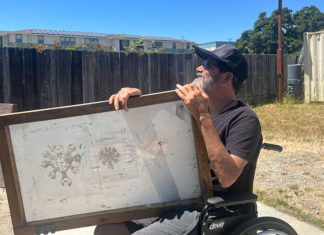 Matt Scott Seeks Help on His Road to Recuperation Man holding a large painting on his lap