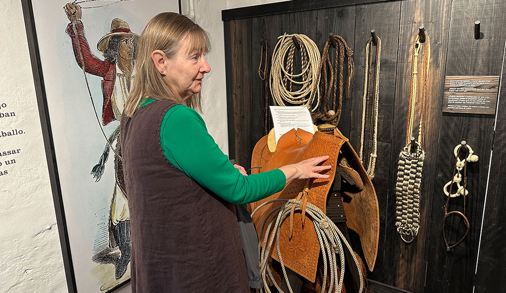 Woman in front of a wall display of historical artifacts