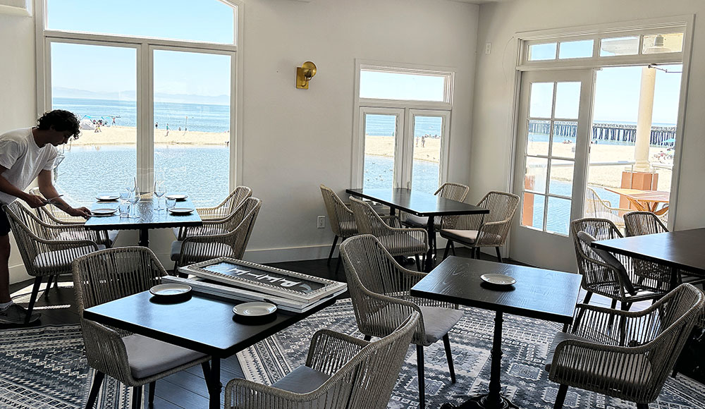 Daniel Dabney sets a table inside the new Pete’s Fish House restaurant in Capitola Village.