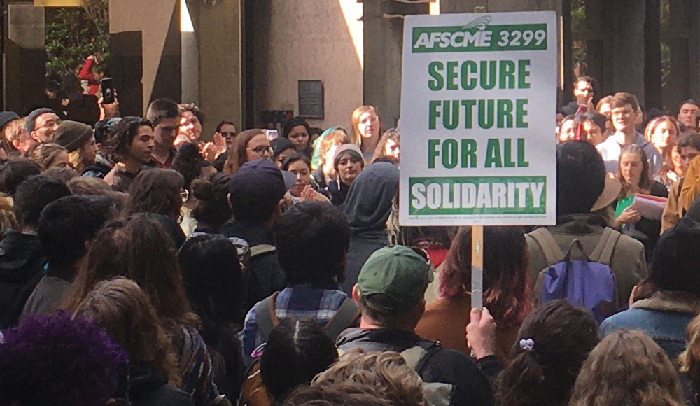 Crowd of protestors with a union sign reading 