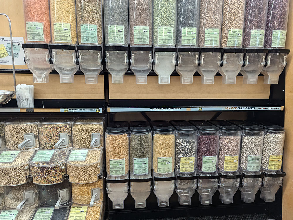 Canisters of bulk beans for sale at a market