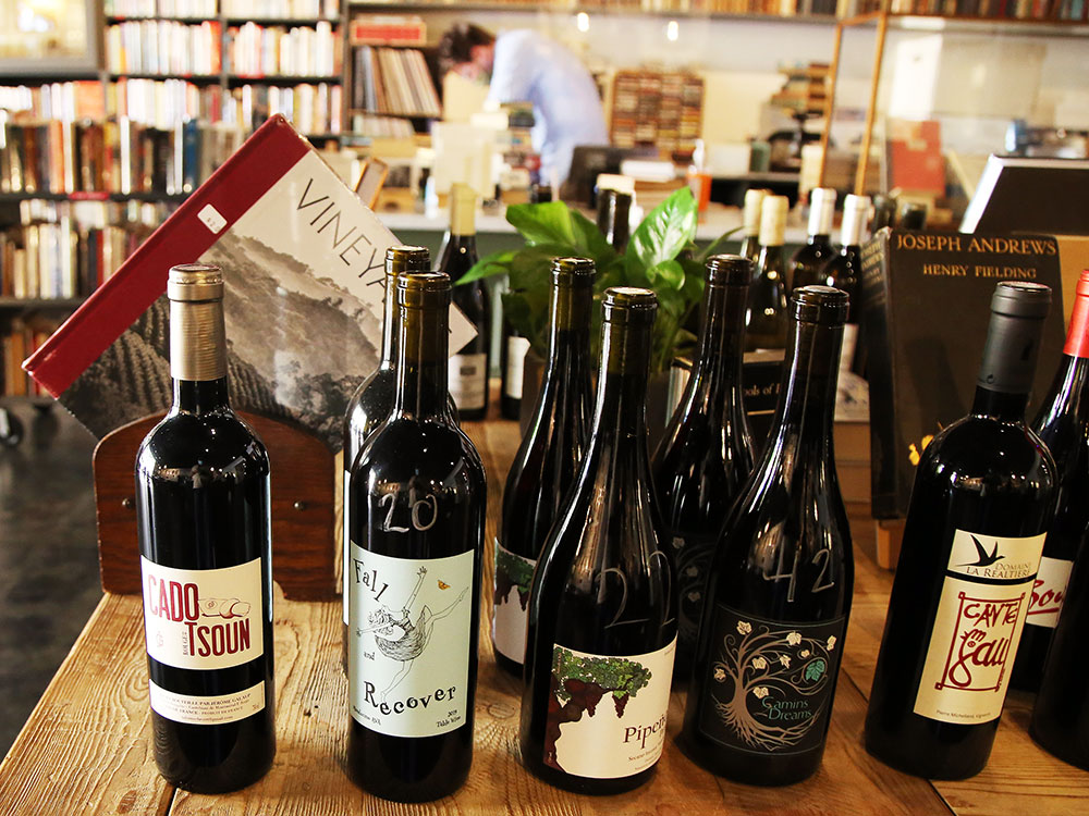 Bottles of wine sitting on a wooden table inside Bad Animal, a bookstore/restaurant in Santa Cruz