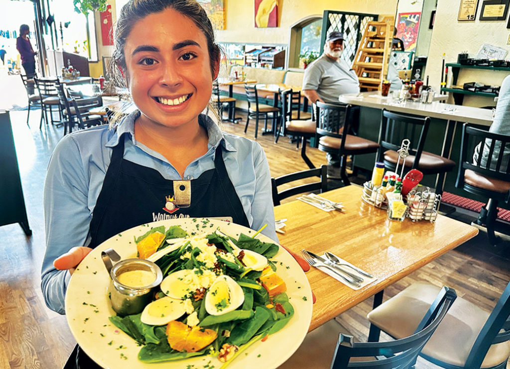 Server holding up a plate of food in a restaurant