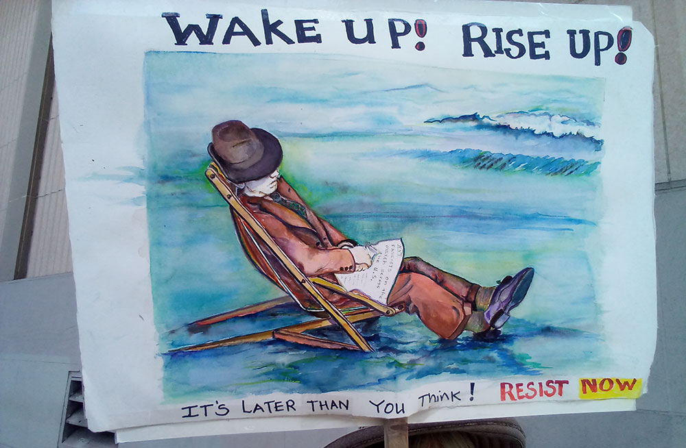 photo of the week, a protest sign with art by Maureen O'Connell