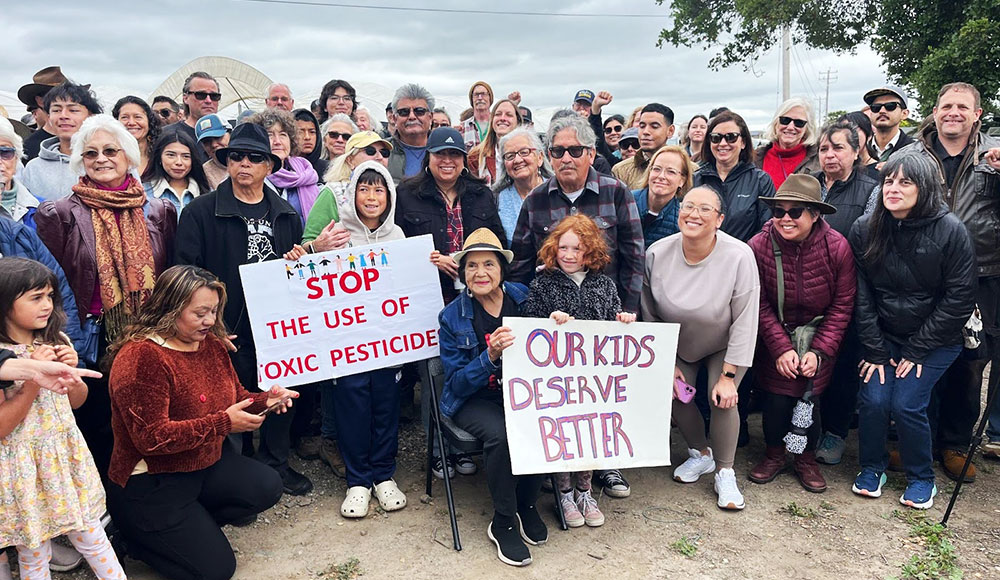 People at an outdoor meeting with signs