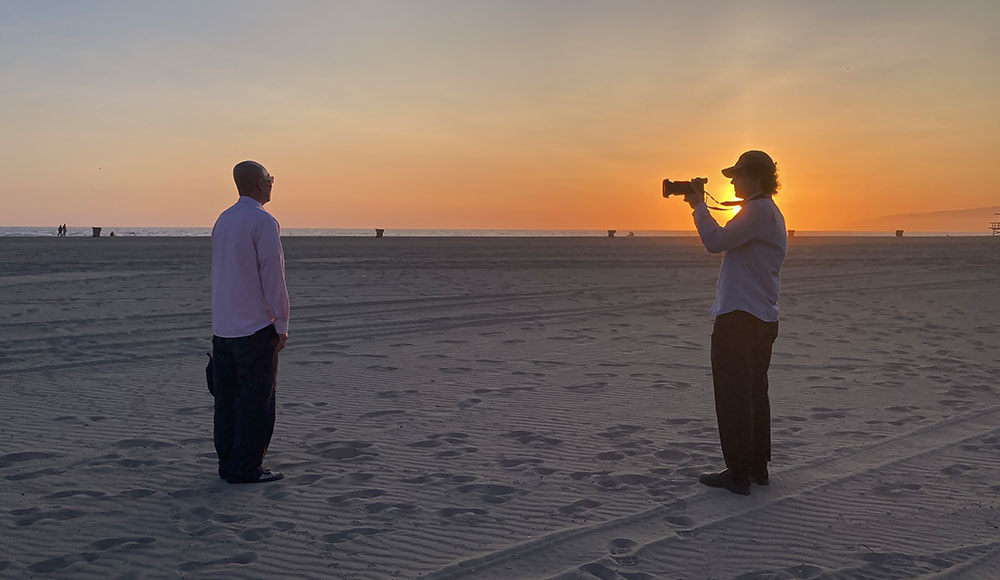 Person with a camera interviewing someone on the beach