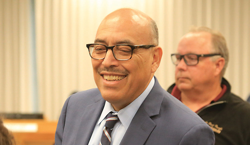 Man in a suit standing in front of another man in a room
