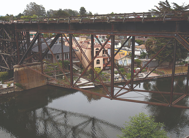 Old-fashioned wooden rail bridge high above a narrow river