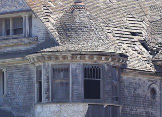 End of an Era Closeup of the upper story of a dilapidated Victorian home